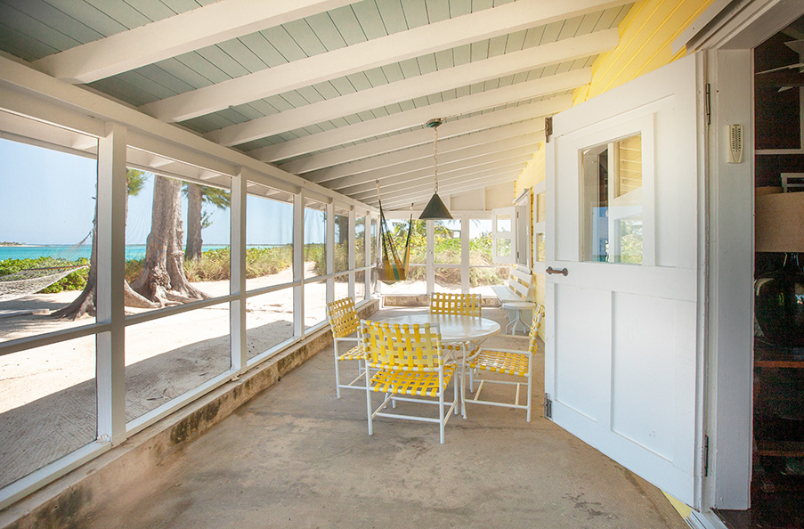 Spacious screen porch stretches the full front of Seagrape and features lighting, hammock, table and chairs.